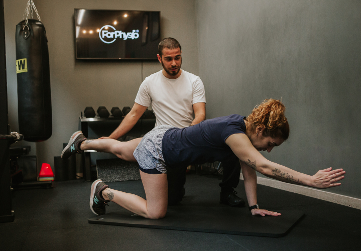 Imagem de um profissional a ajudar o paciente num exercício de fisioterapia.