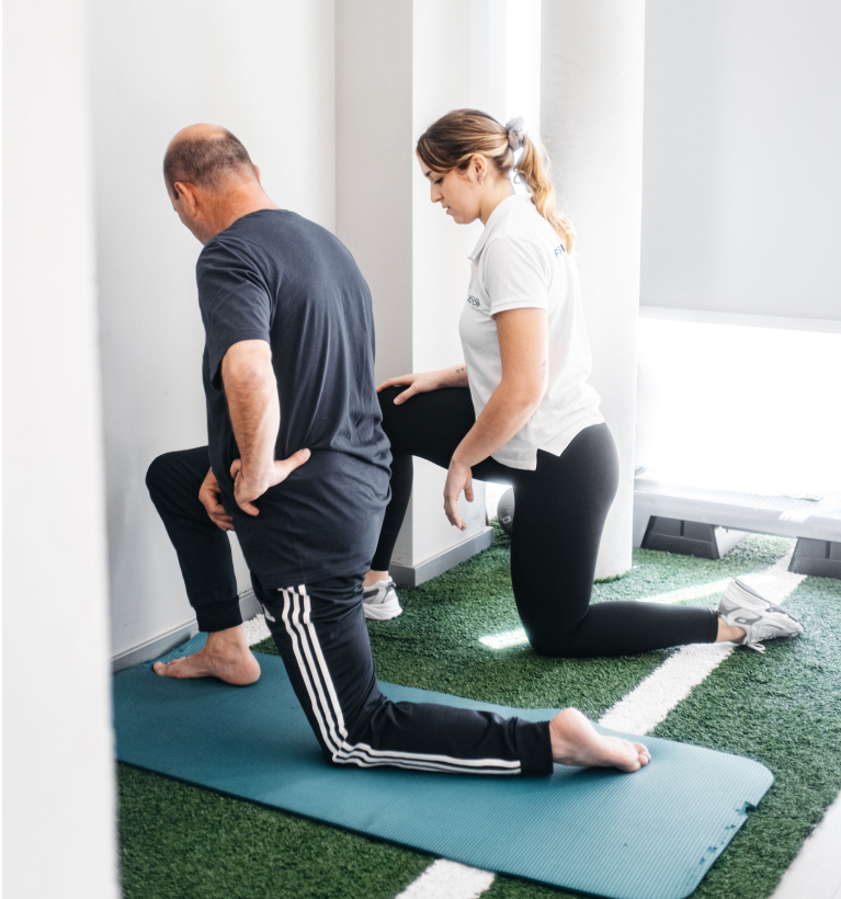 Imagem de uma profissional da ForPhysio a auxiliar a sua paciente num exercício de alongamento.